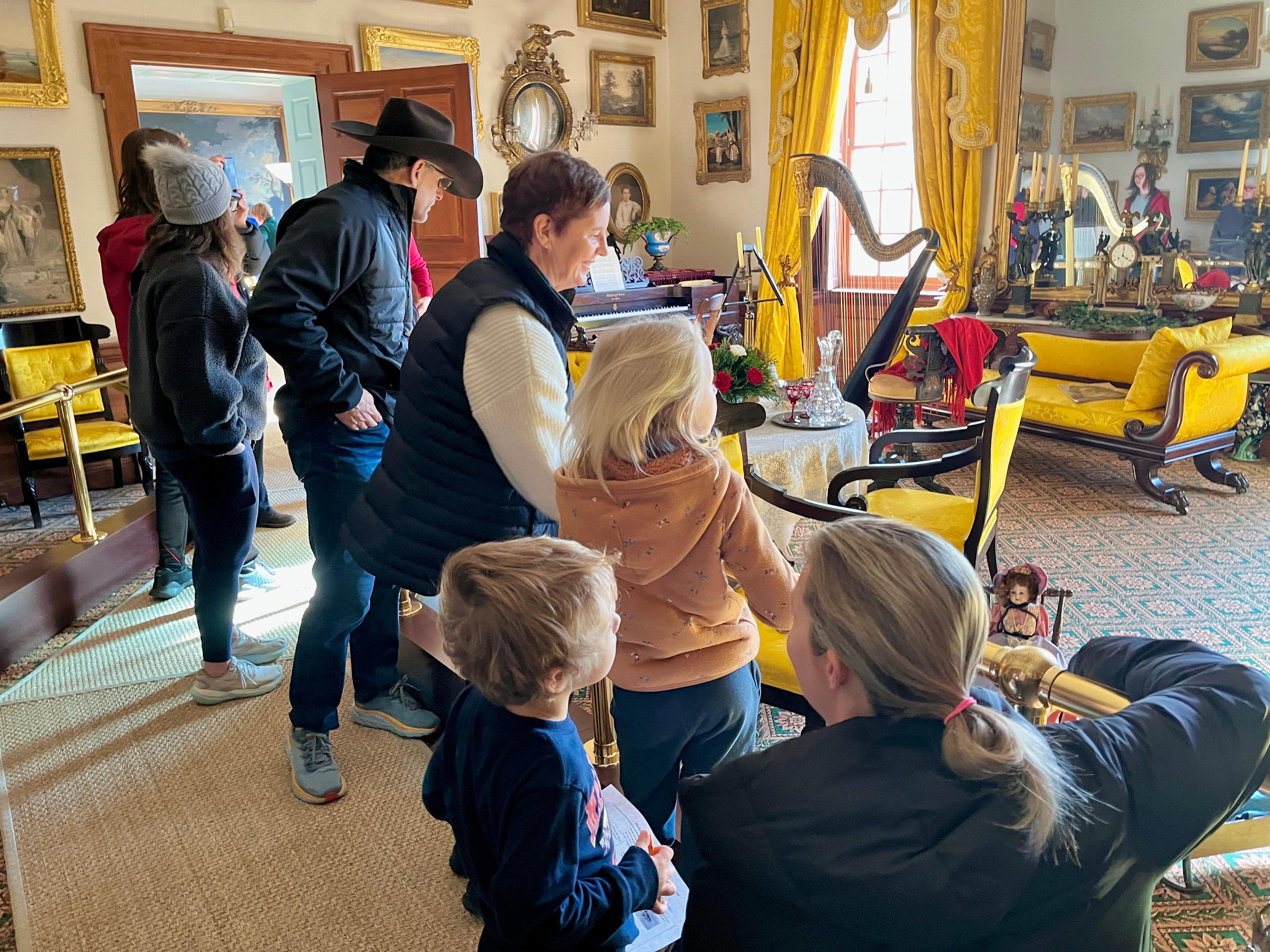 Visitors on a tour of the mansion, looking around the music room