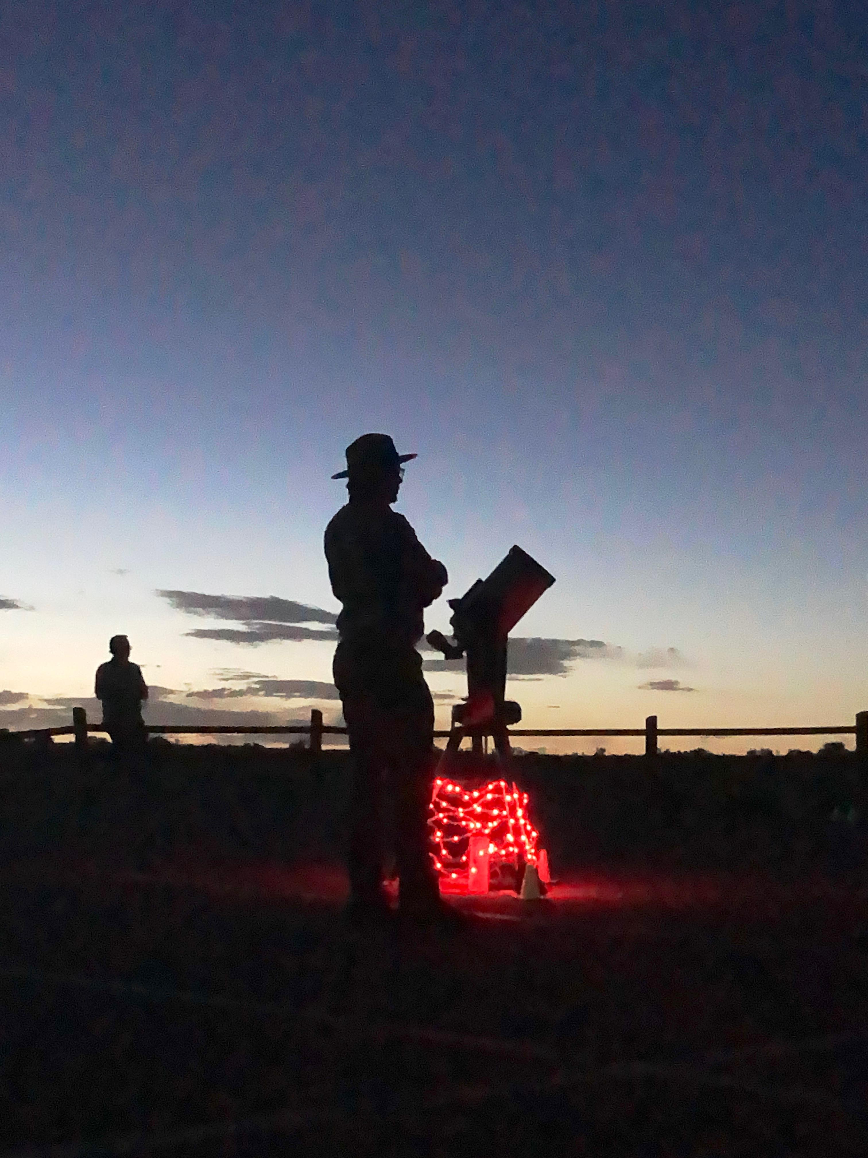 Silhouette or a ranger and telescope