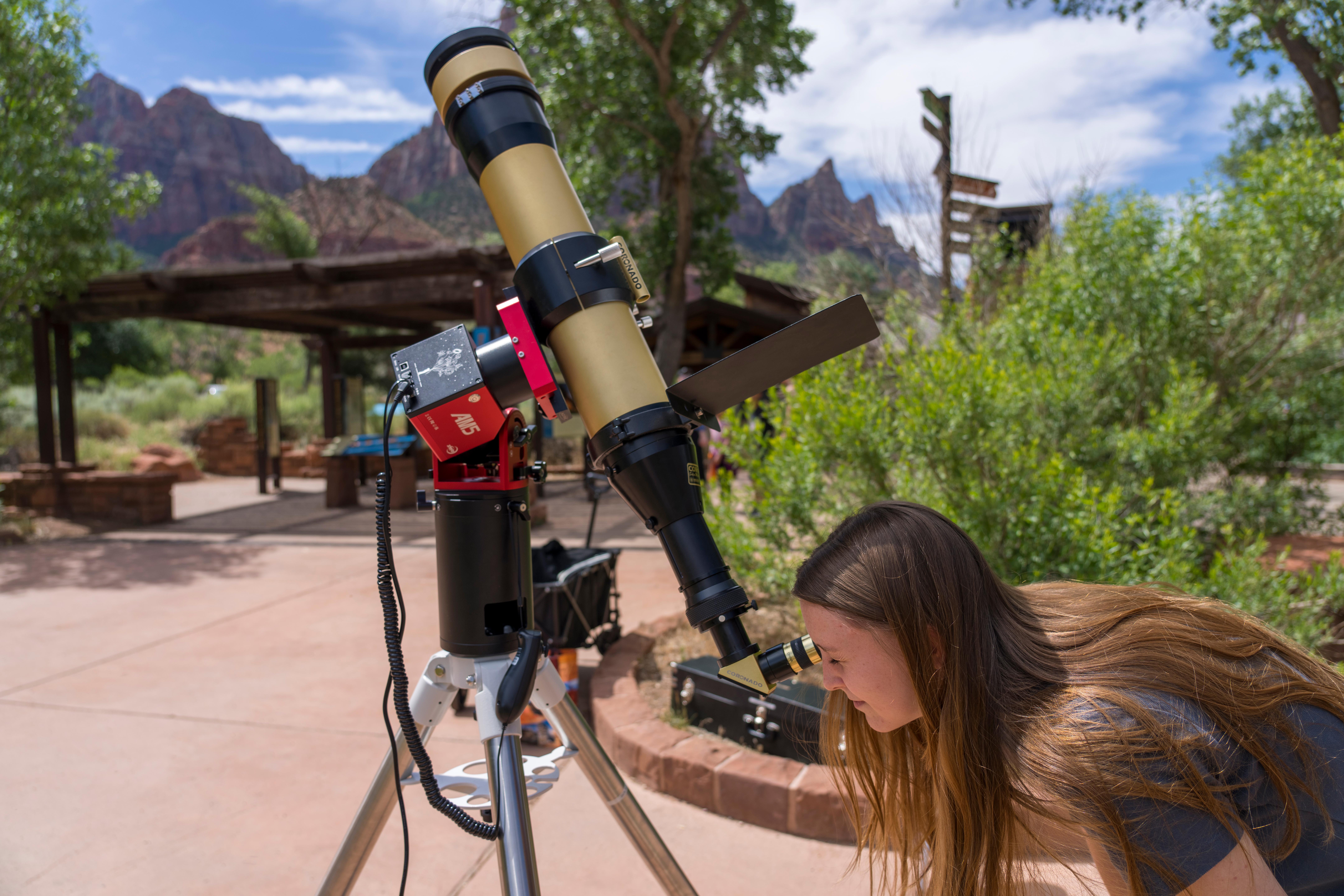 A visitor looking through a solar scope