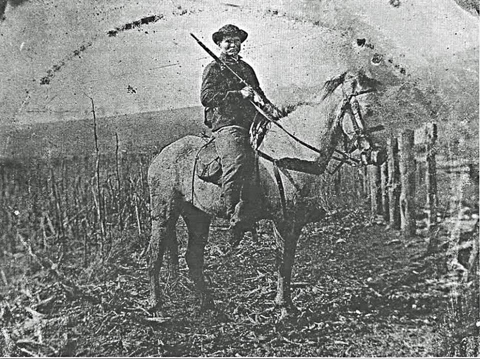 Union soldier sitting on mule with a Spencer repeating rifle leaning on his right shoulder.