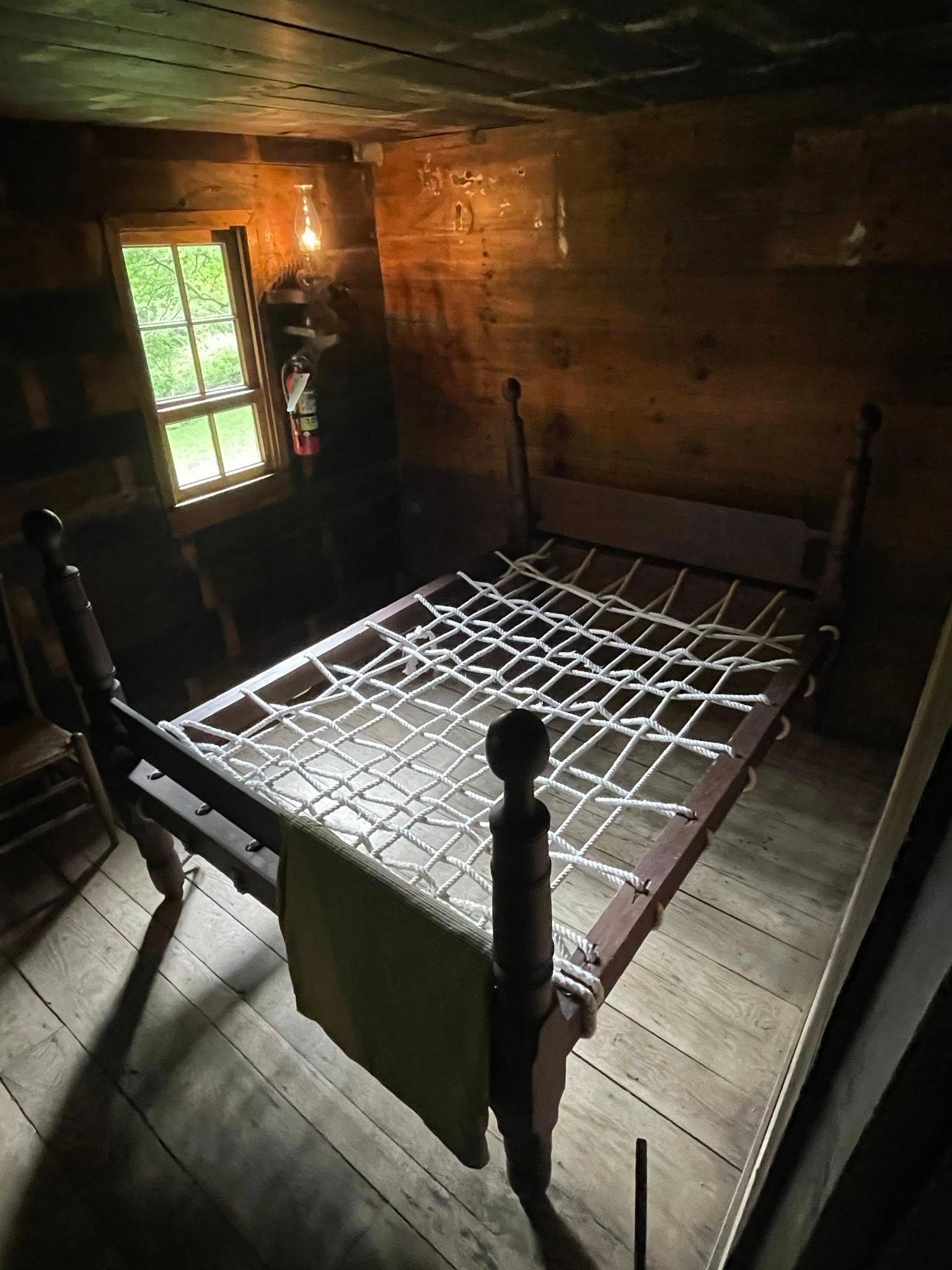 A rope bed sits inside Brinegar Cabin