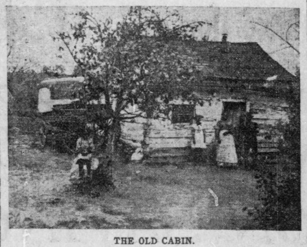 A black and white image of a small, single story cabin with several African American people in front