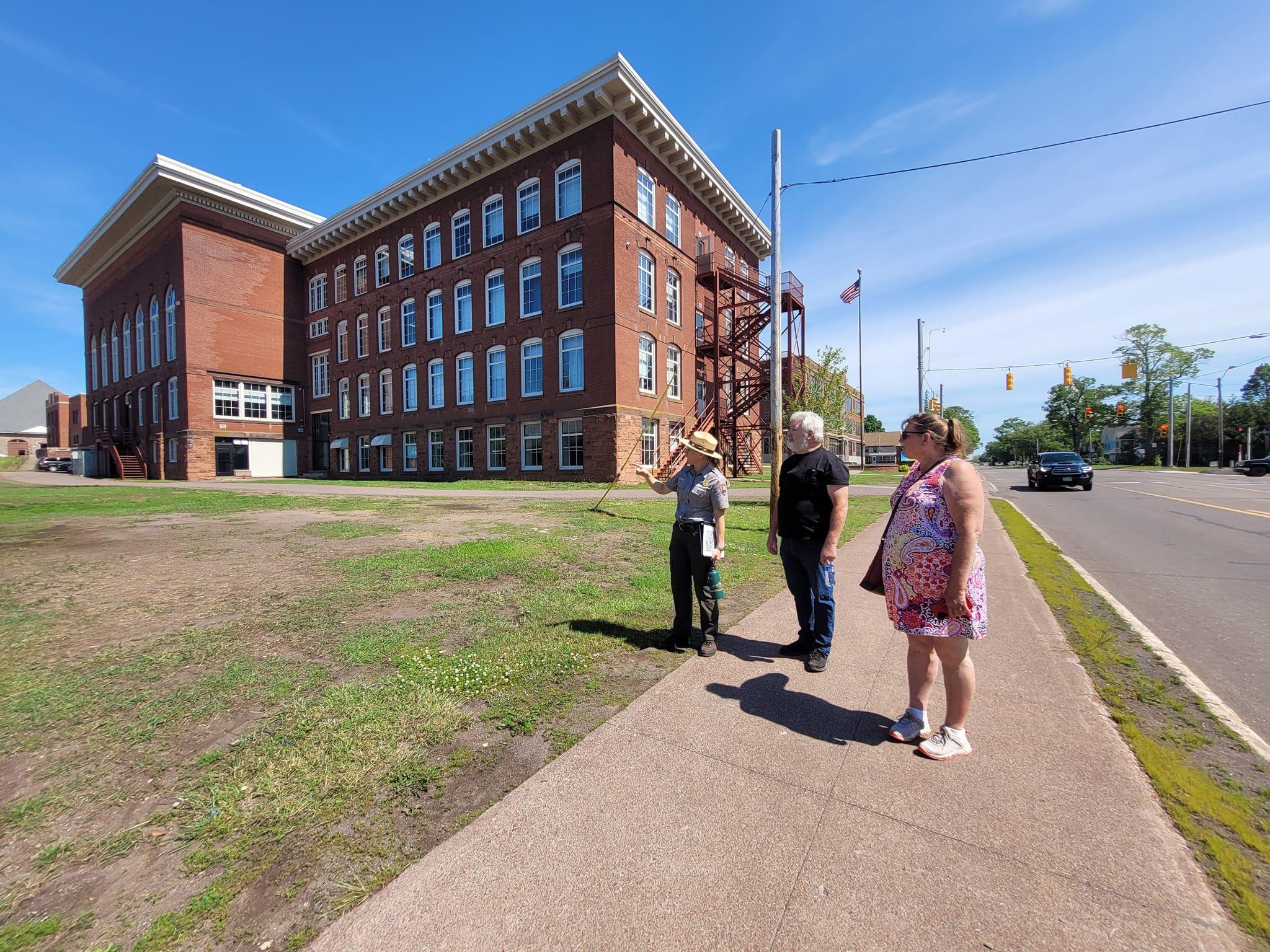 A park ranger talks with visitors about historic buildings.