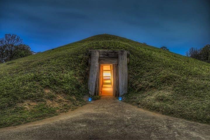 An illuminated entrance to a Mississippian Earthlodge at dusk