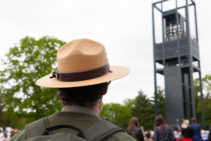 Park Ranger looks upwards at a large gray bell tower.