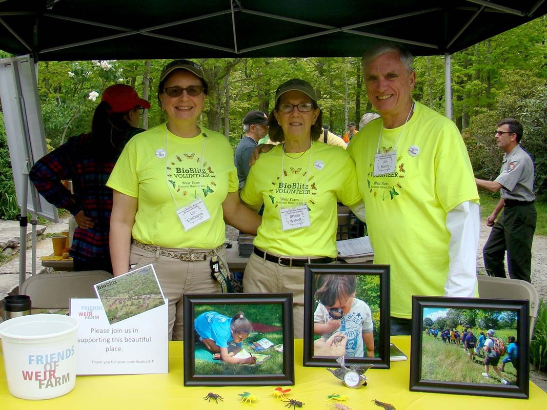 A group of people standing under a tent with a table filled with activities and picture frames
