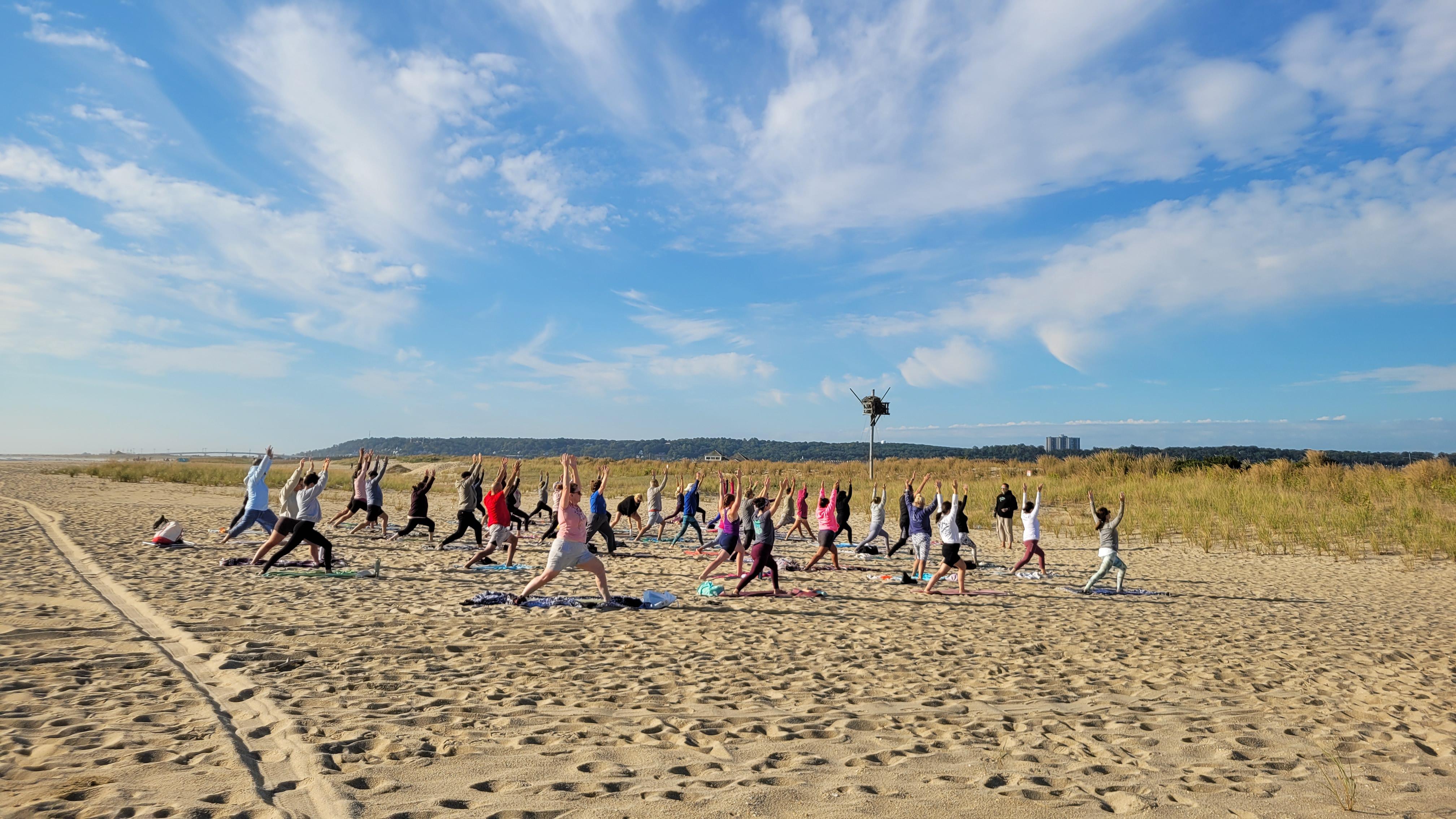 Group of people doing yoga on the beach