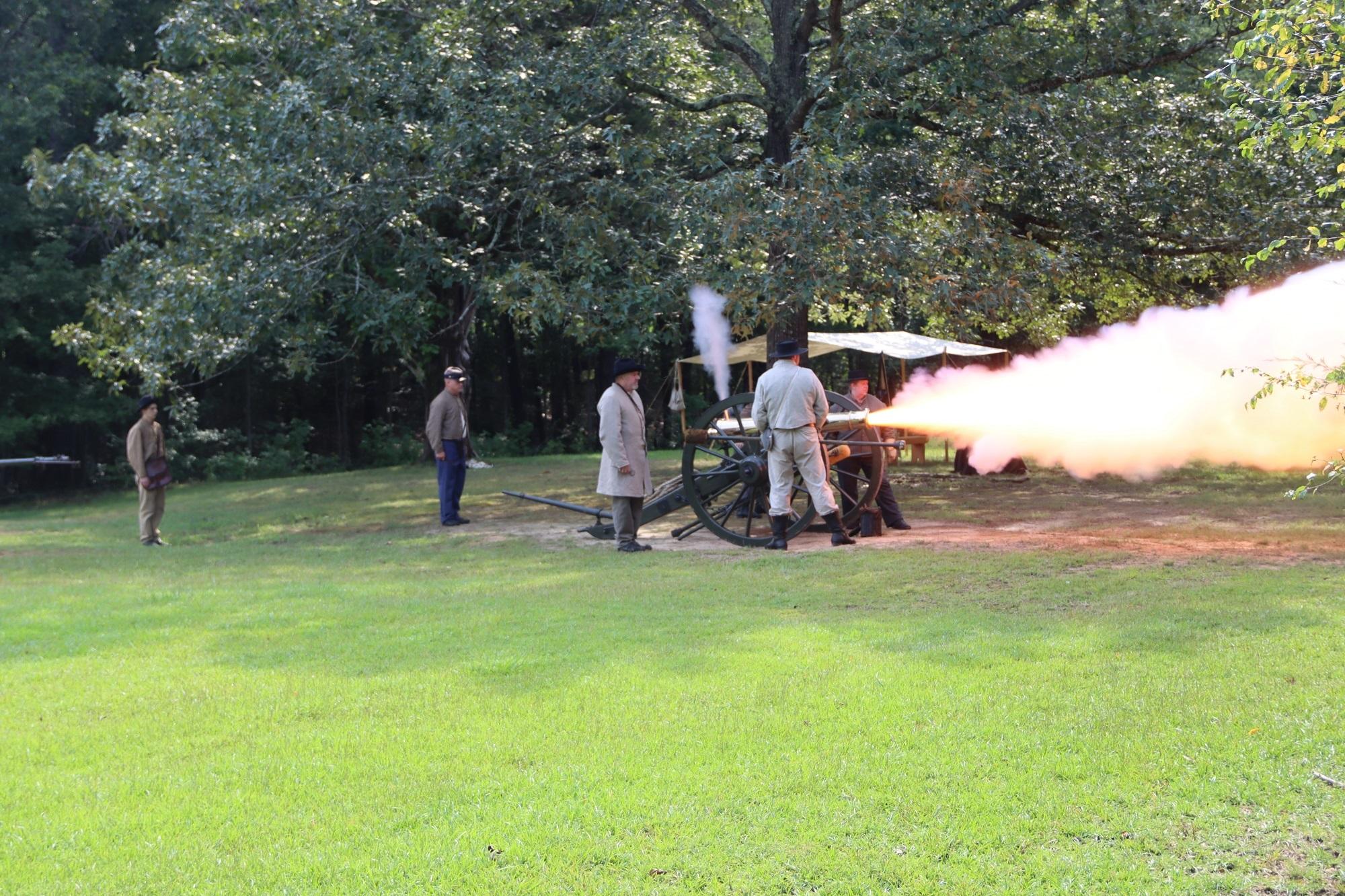 Living historians fire a bronze cannon.