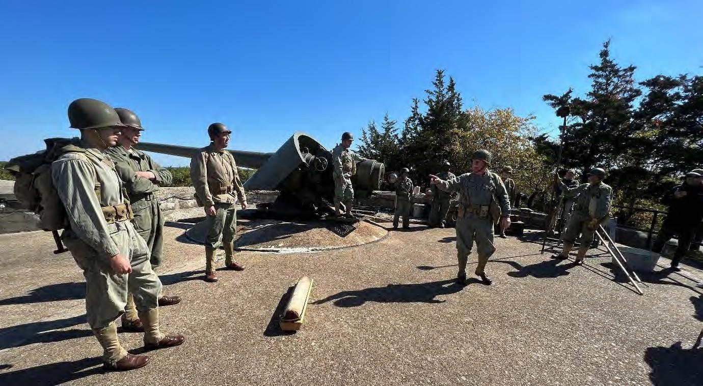 Group of men in uniform beside a historic cannon.