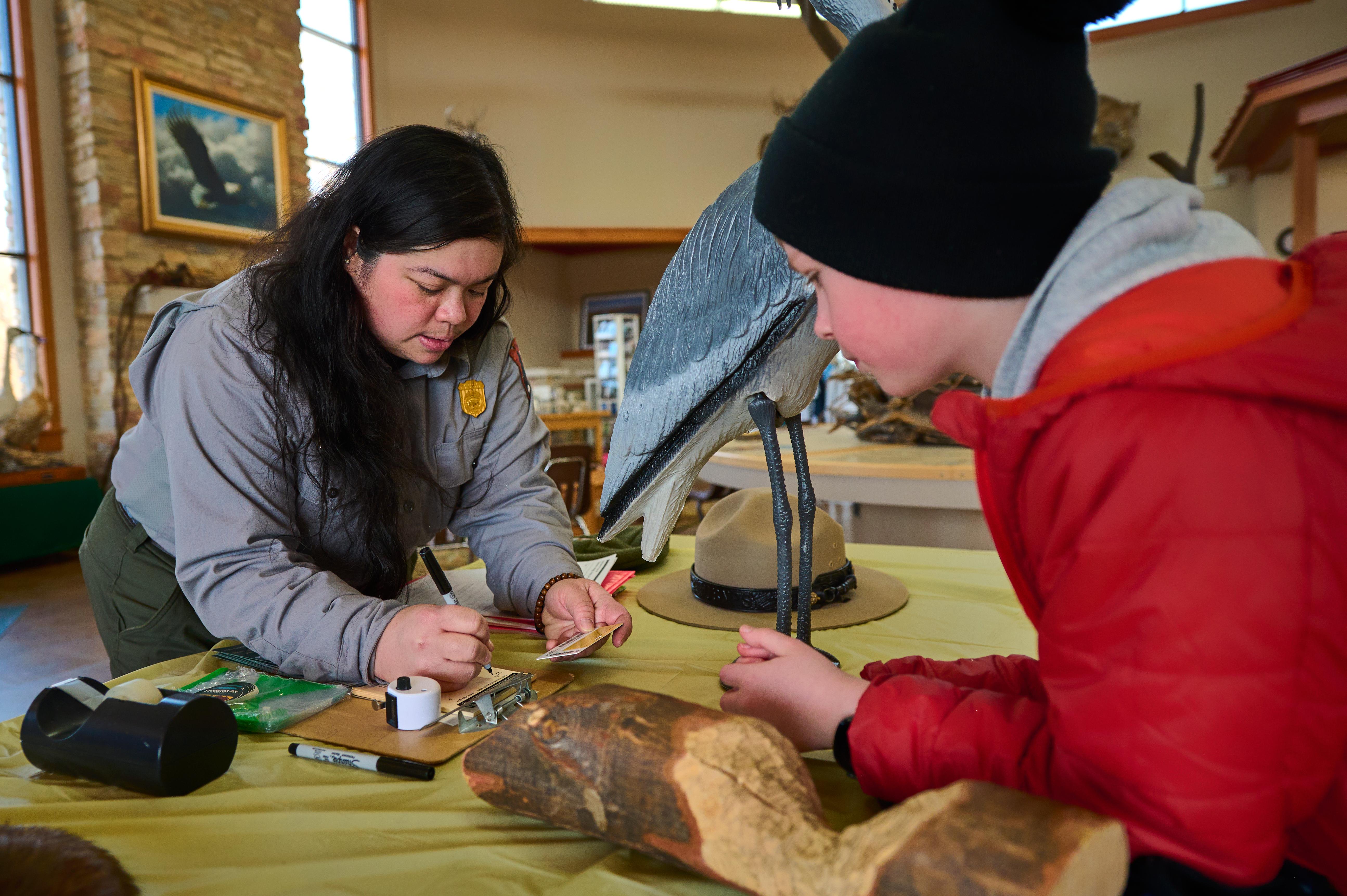 A park ranger issues a park pass to a young visitor