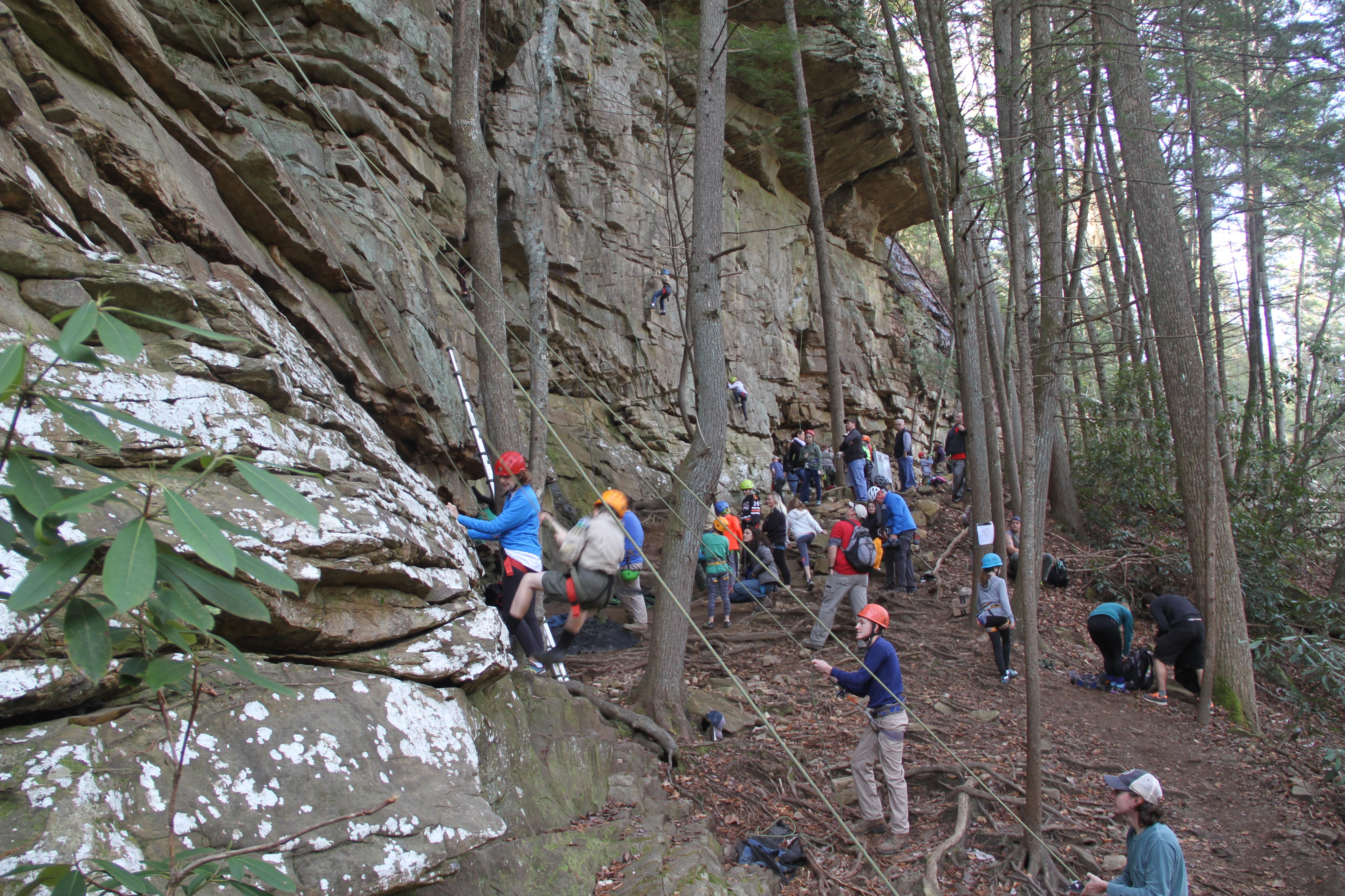 A group of rock climbers at a rock wall.