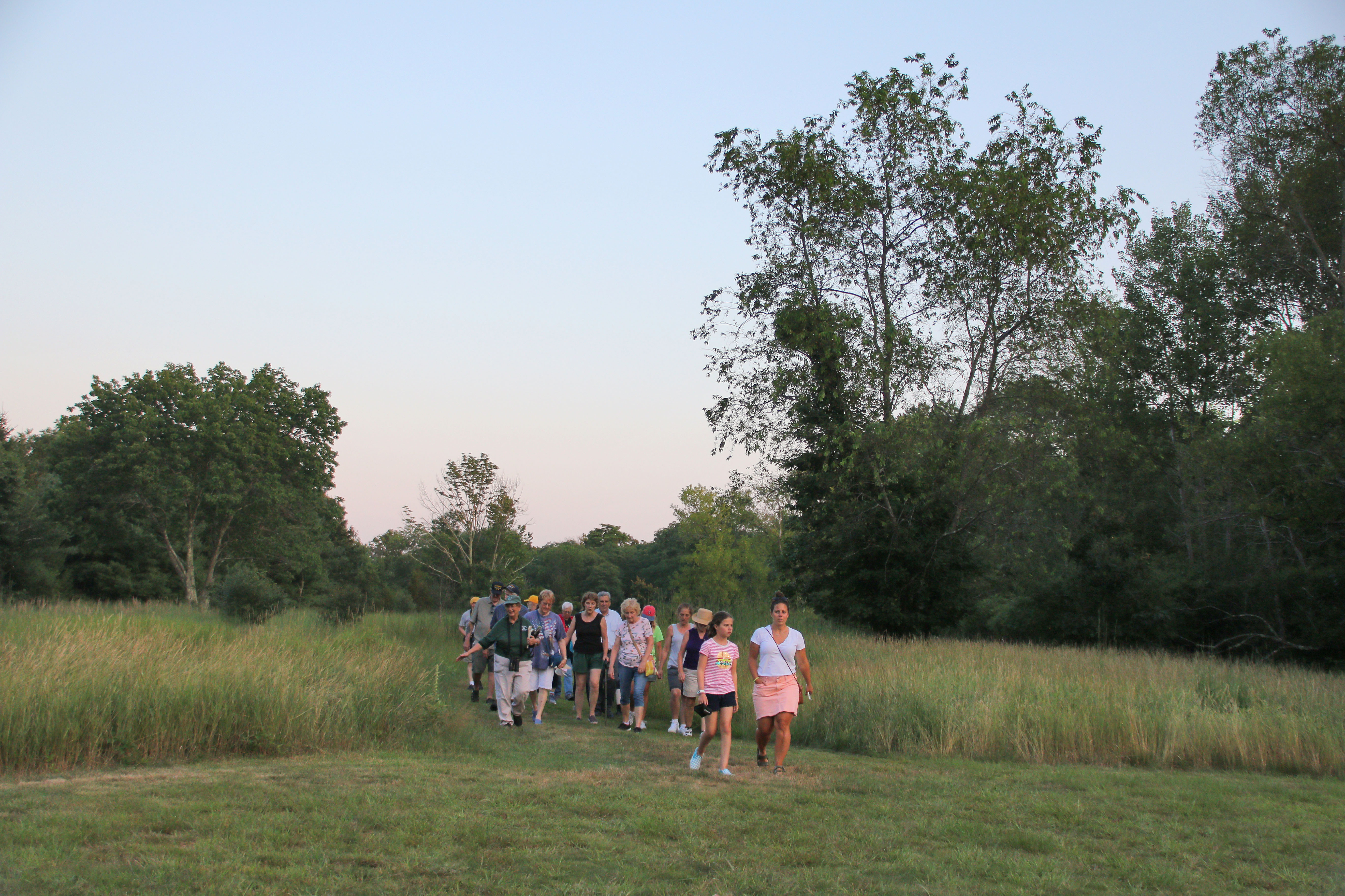 Group of people walking through a field at Blackstone River State Park