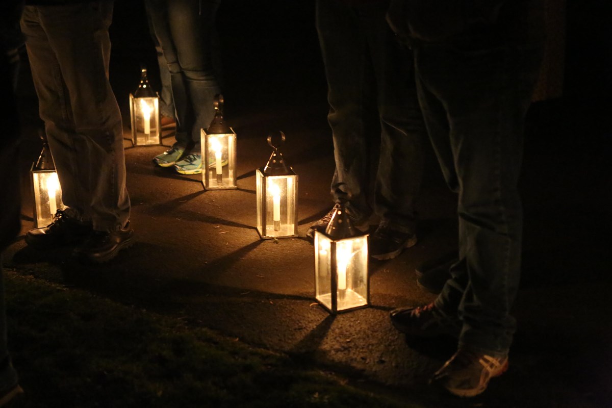 A line of lanterns illuminates the feet of park patrons on a lantern tour