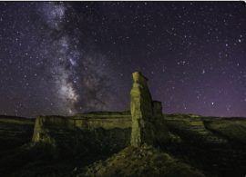 Looking up at Independence Rock Formation with starry skies with the Milky Way in the background.