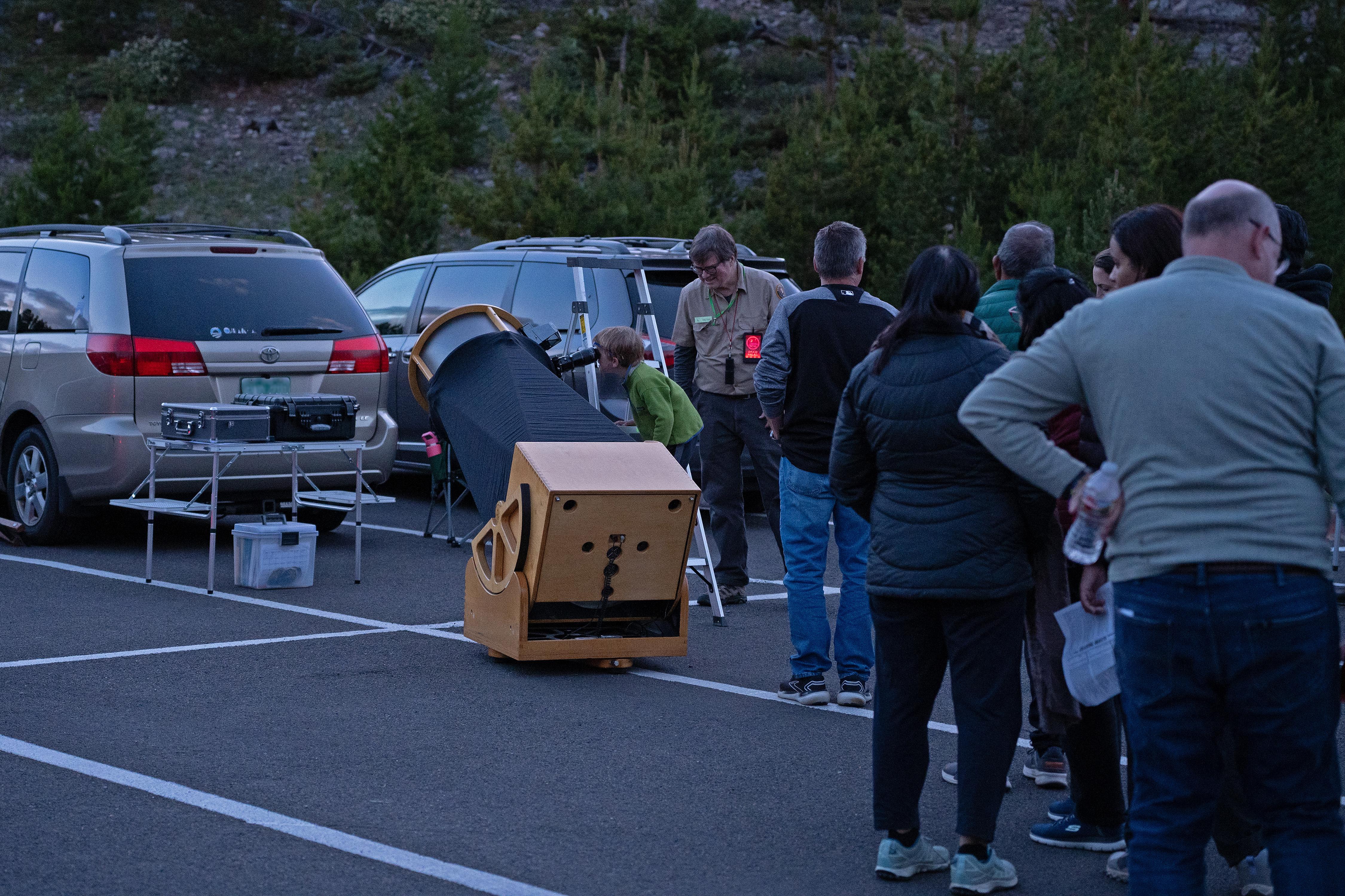 People are lined up to look through a telescope