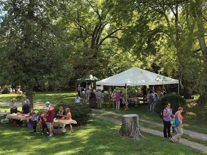 tables and tents display hands-on activies at an outdoor event.