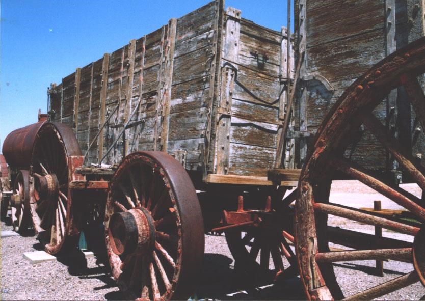 Close up image of two large wooden wagons with rusted metal wheels.
