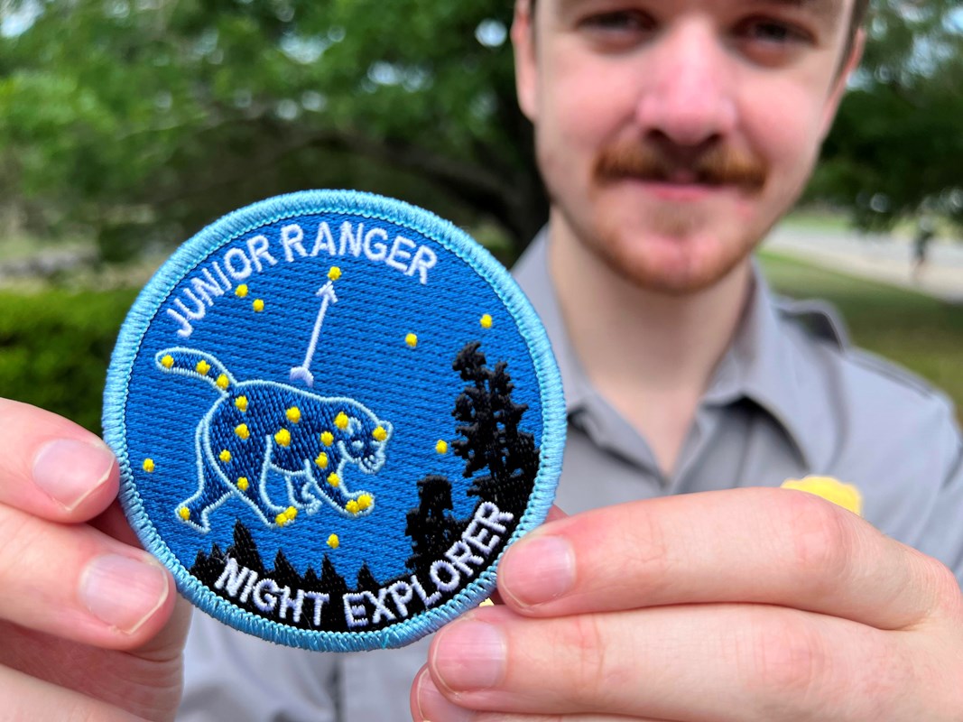 A blue cloth patch with stars that form a constellation. It reads 