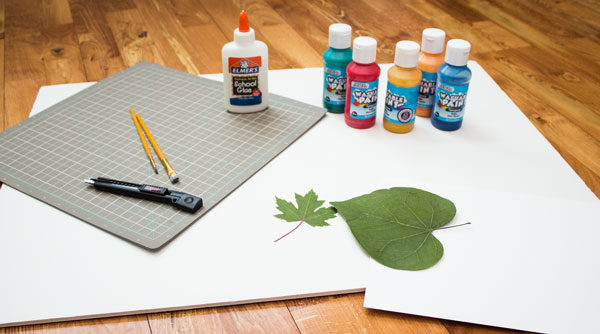 picture of craft paint a leaf, a bottle of glue and boards