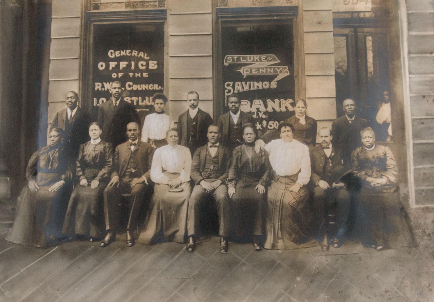 A group of men and women in front of a bank building