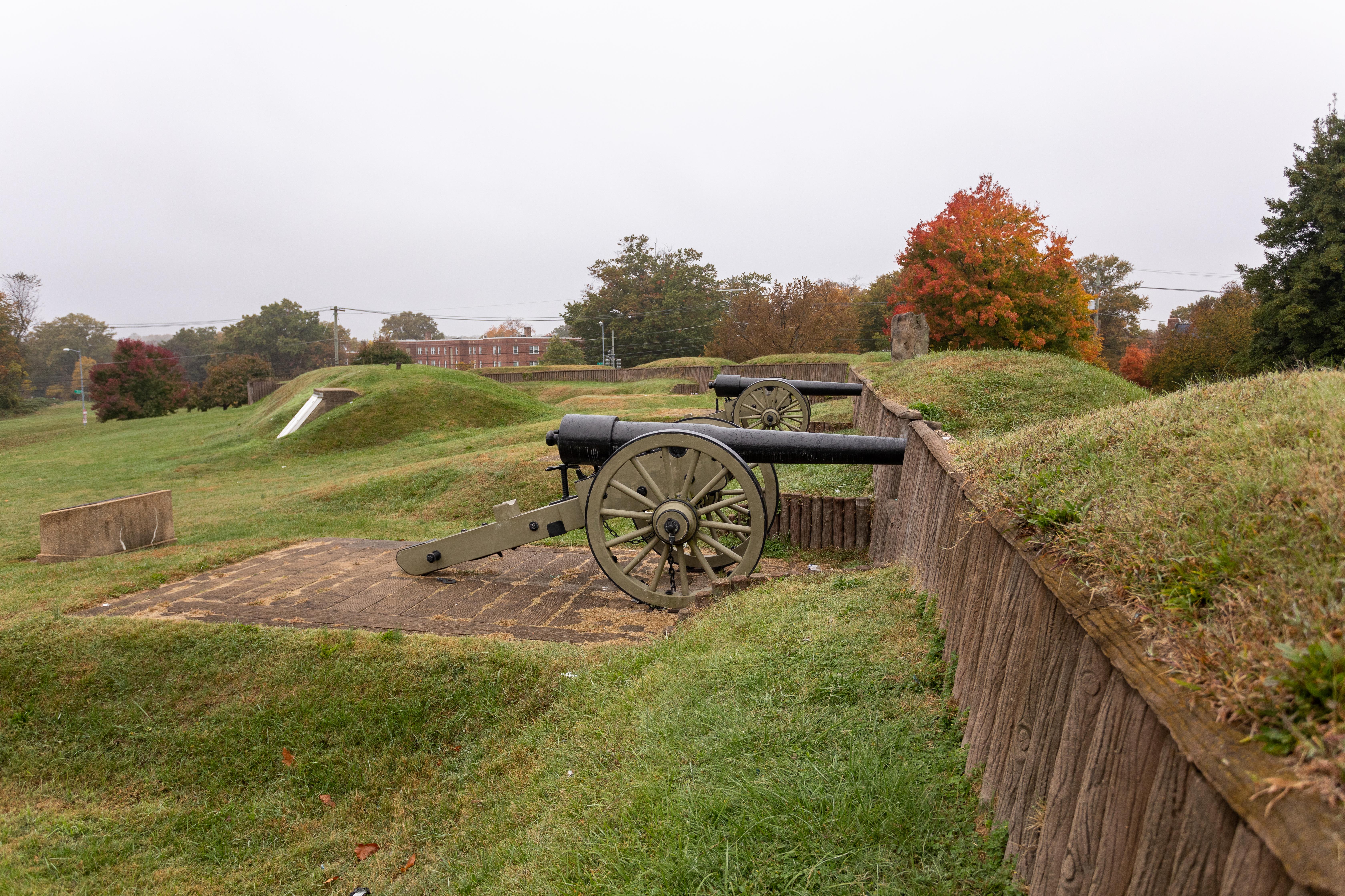 cannons at Fort Stevens amidst the grassy landscape and trees in the distance