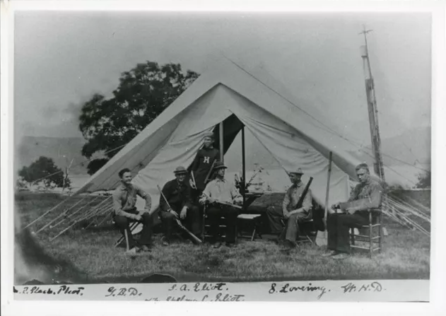 Members of the Champlain society posing for a photograph in front of their tent.