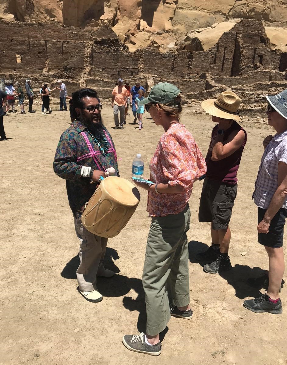 A visitor talking with a drum performer at the Summer Solstice event in 2019.