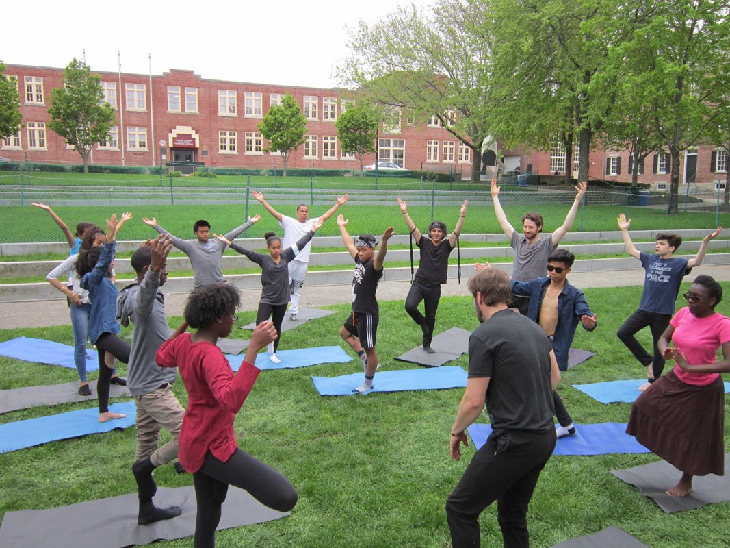 A group of teens practicing yoga in an urban park