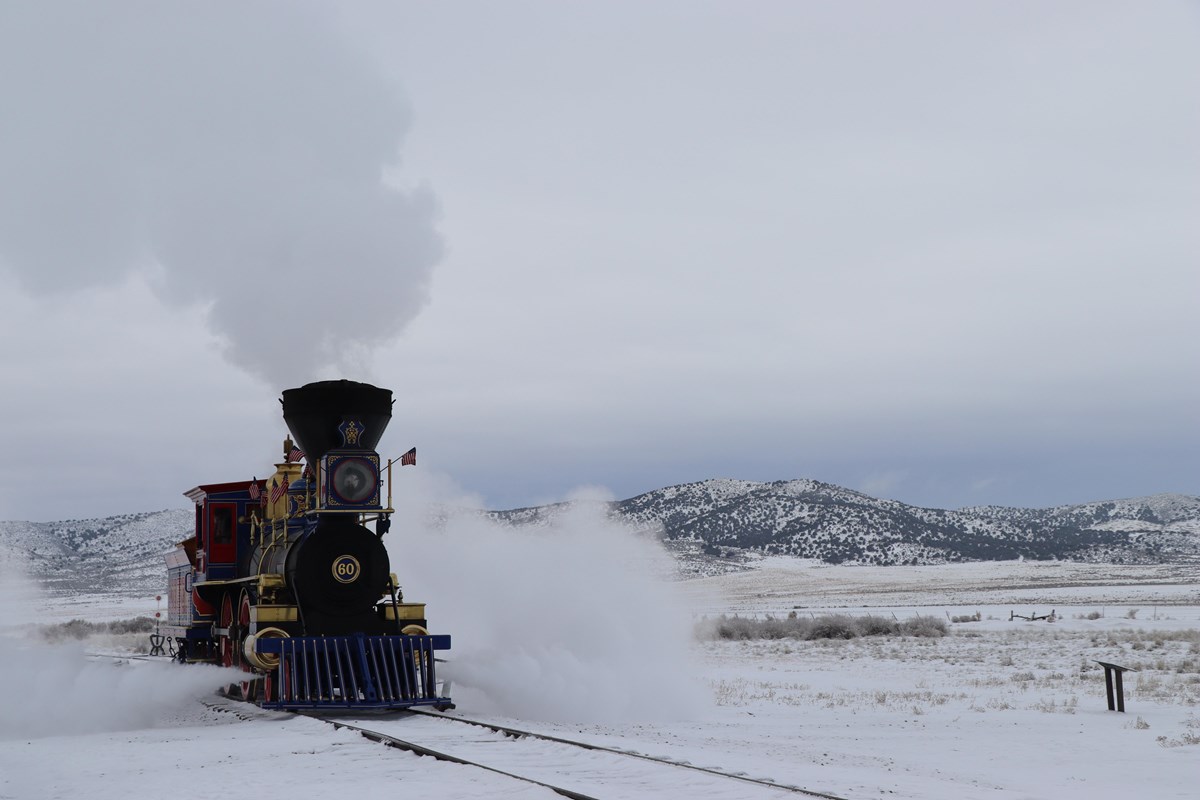 Jupiter a steam Locomotive running on a trail road track covered in snow.
