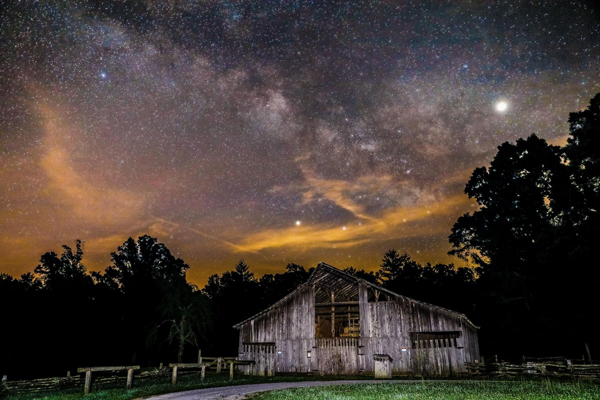 a barn with milky way overhead