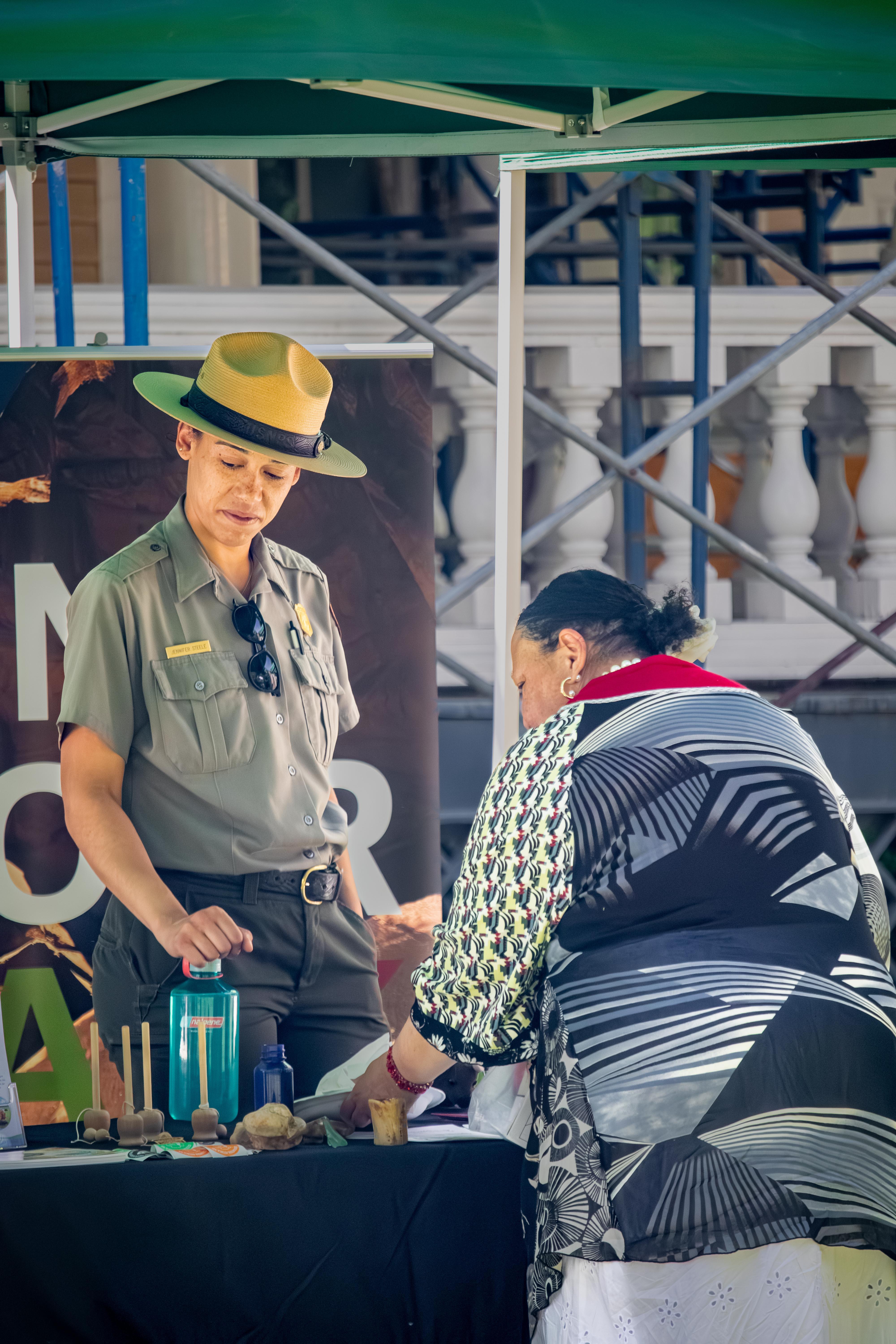 Park ranger talking to a visitor at an outdoor tent