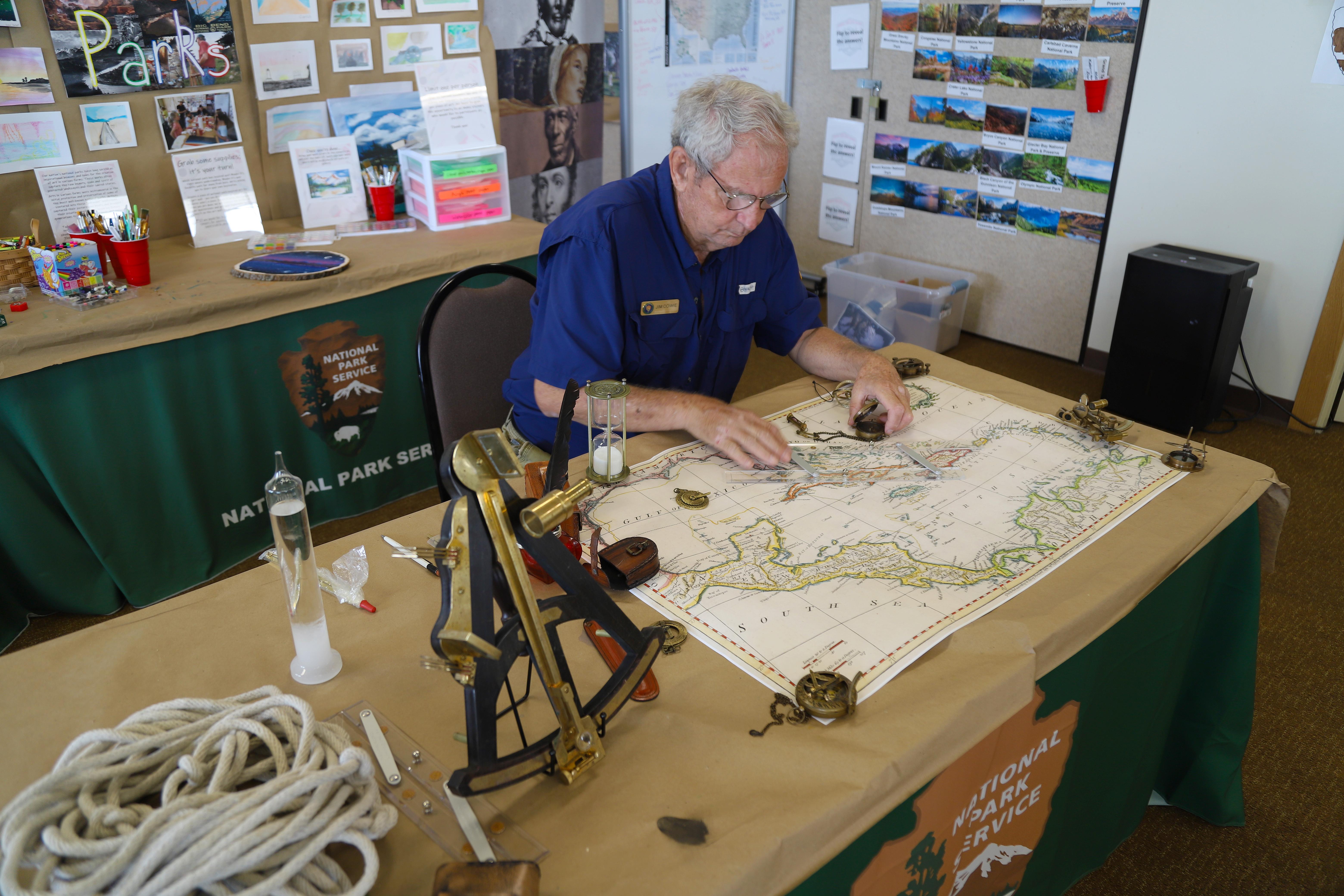 A Volunteer reads a map with navigational tools.