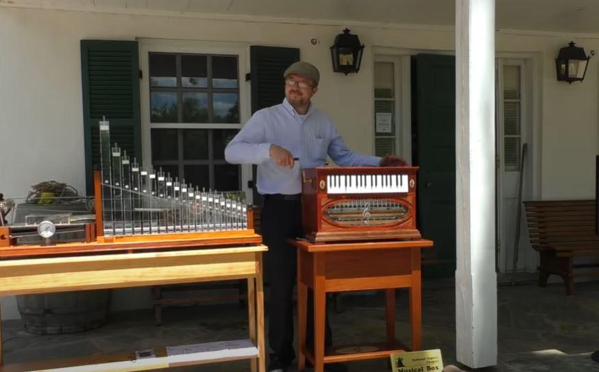 man playing a music organ grinder