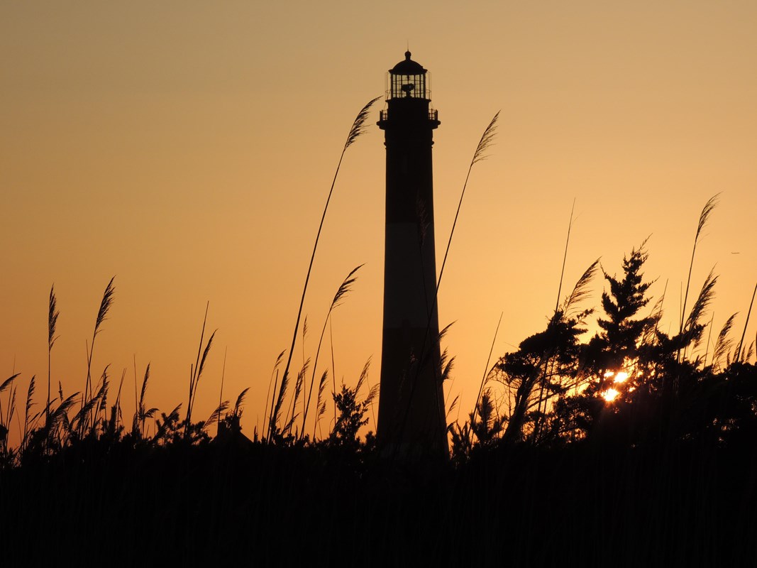 A lighthouse stands in a beautiful sunset
