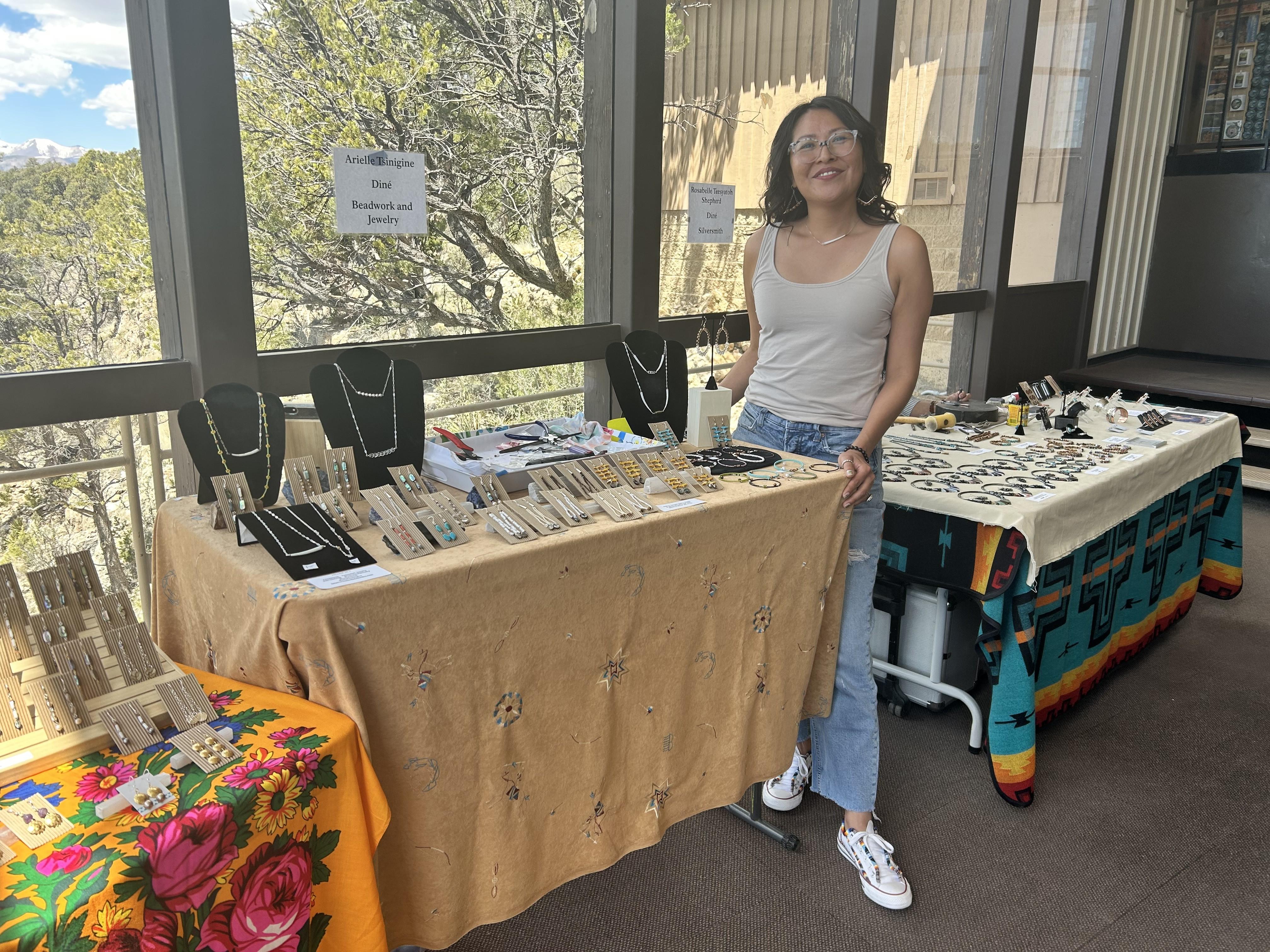 Arielle Tsinigine stands in front of her artwork at Walnut Canyon