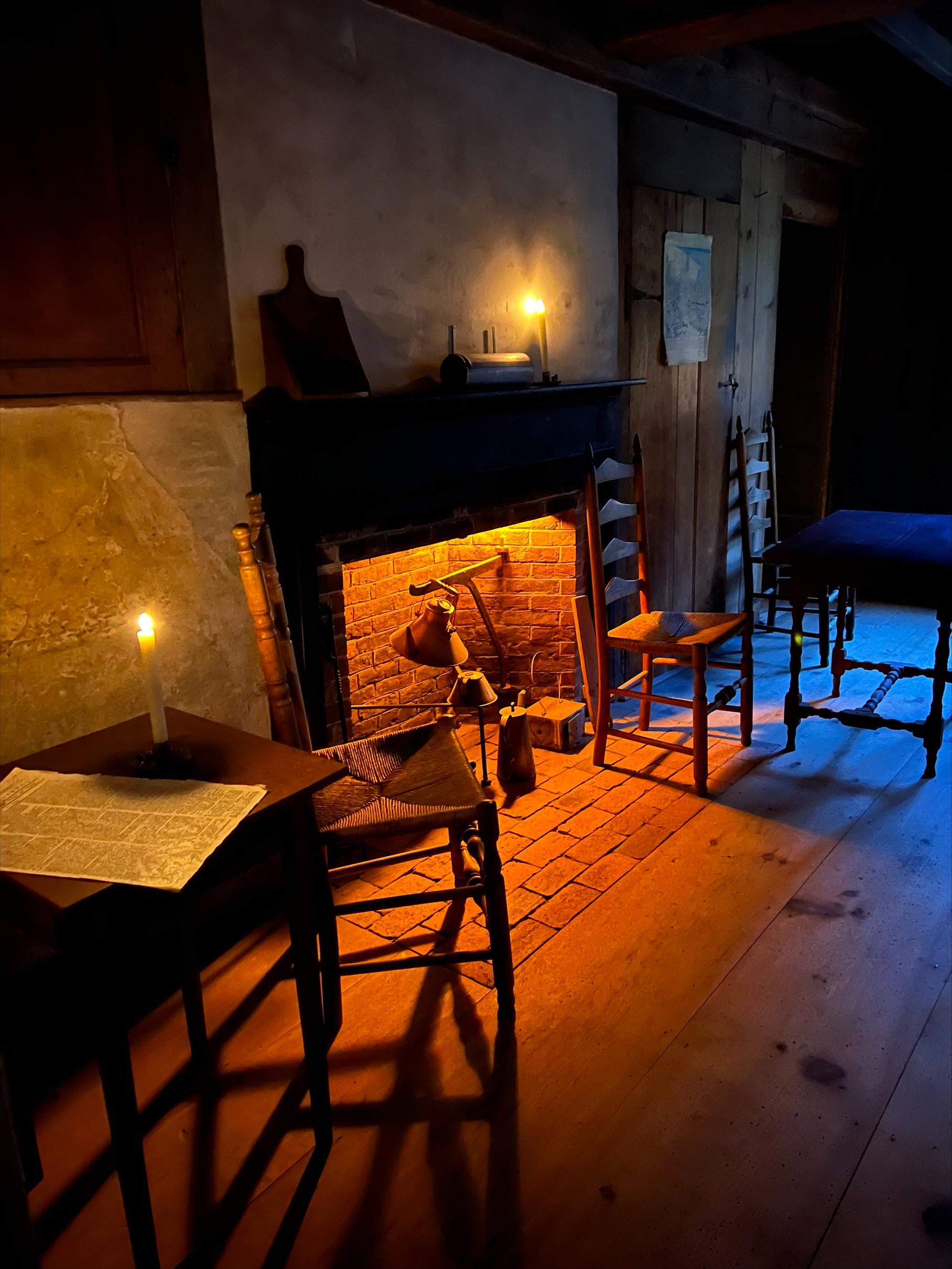 A tavern interior with candles and a fireplace