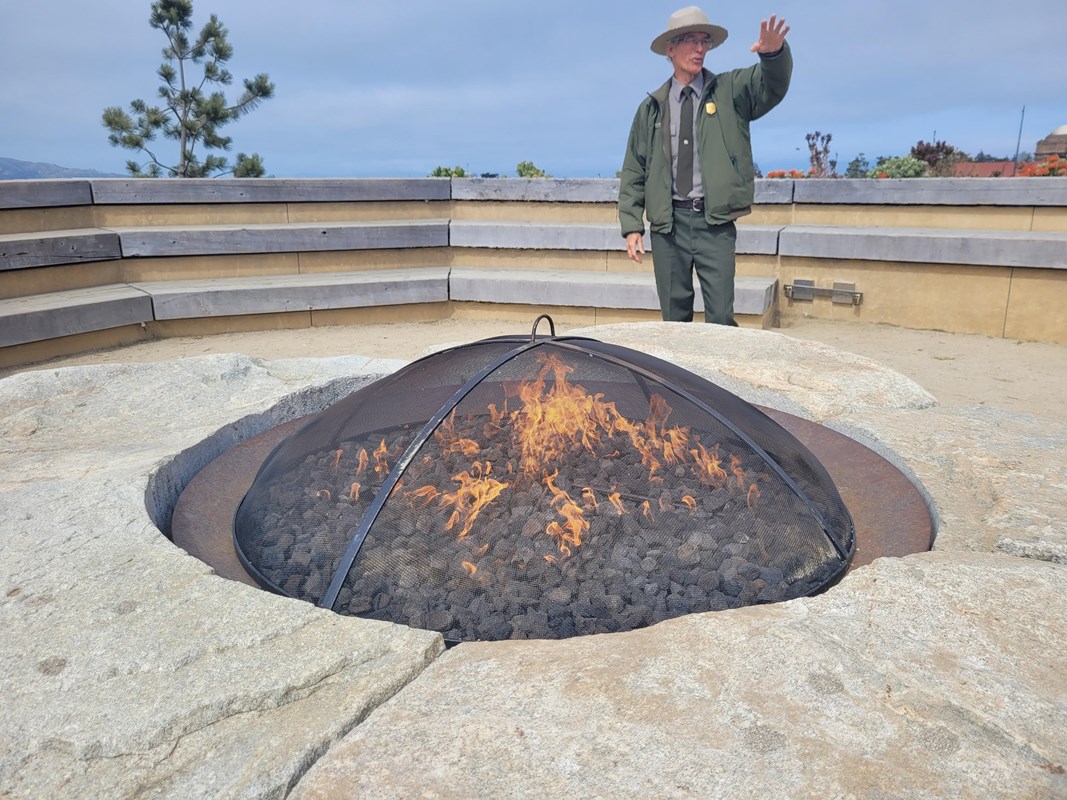 Park Ranger giving a program at the campfire circle. Park Ranger is standing in the middle of circle