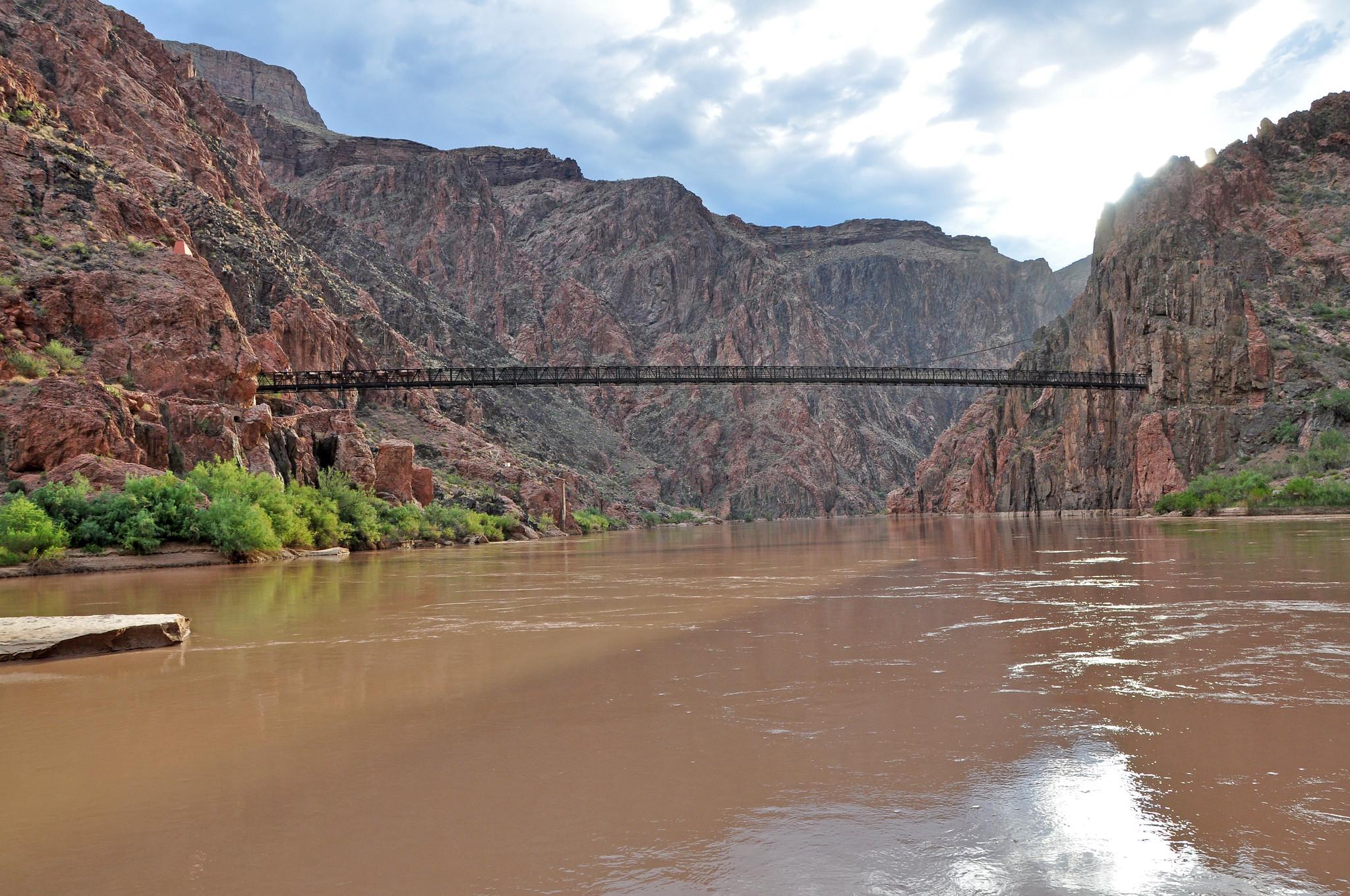 A brown river flows through high rock walls.