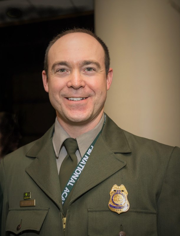 A uniformed NPS official smiles into the camera