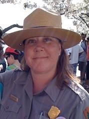 A woman in an NPS uniform smiles into the camera
