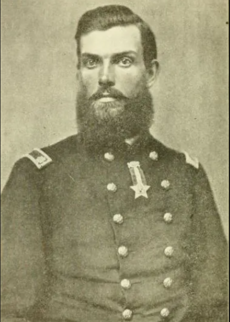 Black and white photo of a bearded man wearing a dark, double breasted uniform coat.
