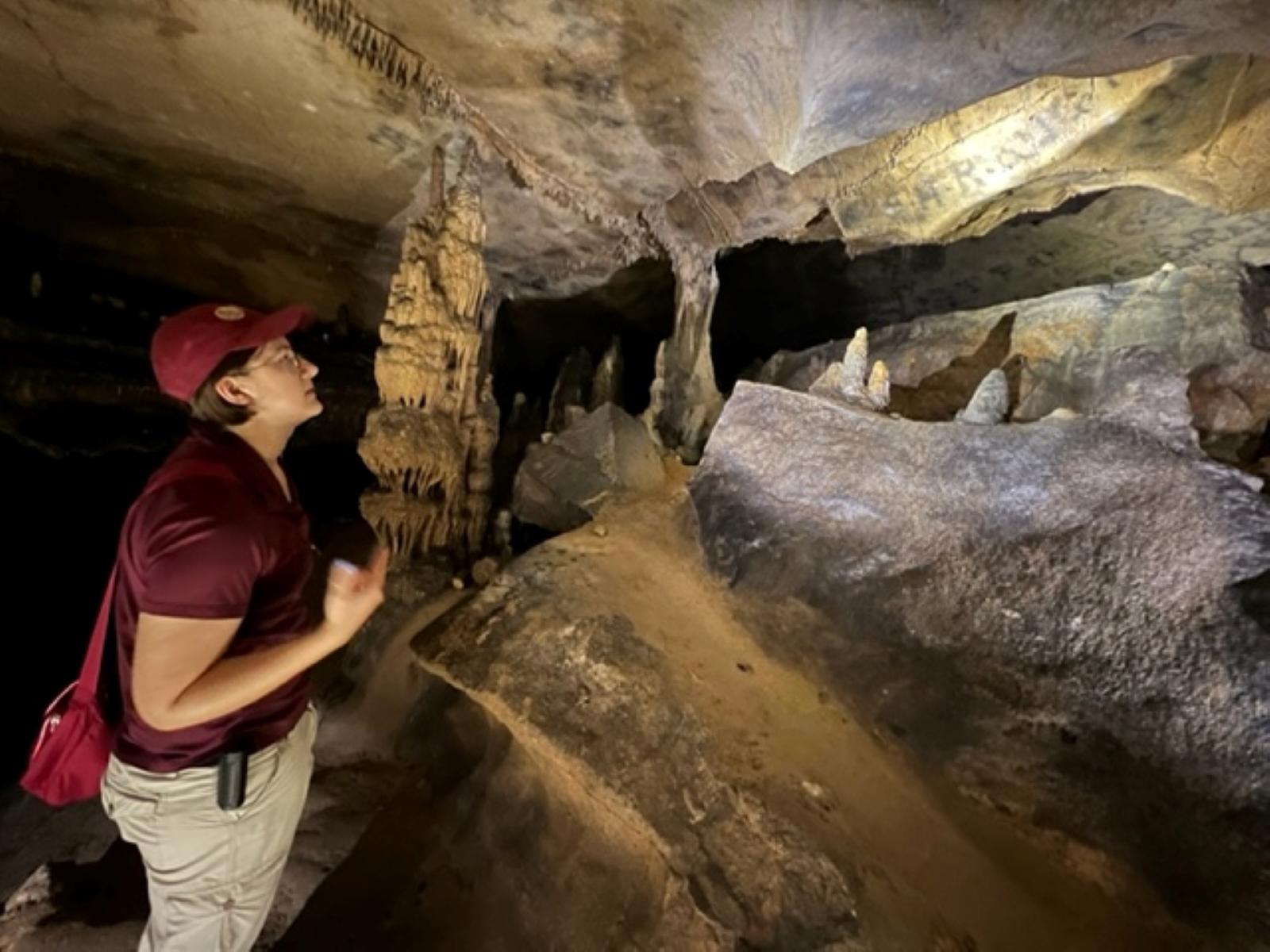young woman talking in front of cave formations