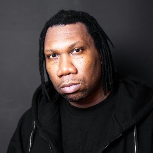 Portrait of KRS-One wearing black shirt and hooded jacket.