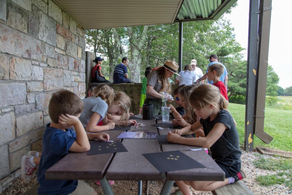 Children sitting at a table participating in a Night Sky Festival Junior Ranger program.