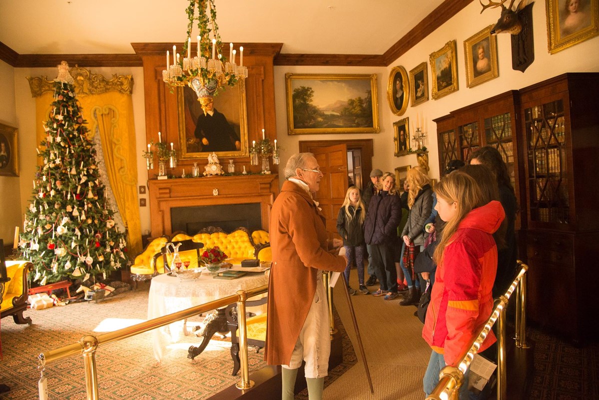 Volunteer greets visitors in the mansion's Music Room