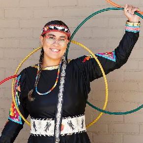 Woman wearing a black dress with beadwork on her dress holding four colorful hoops.