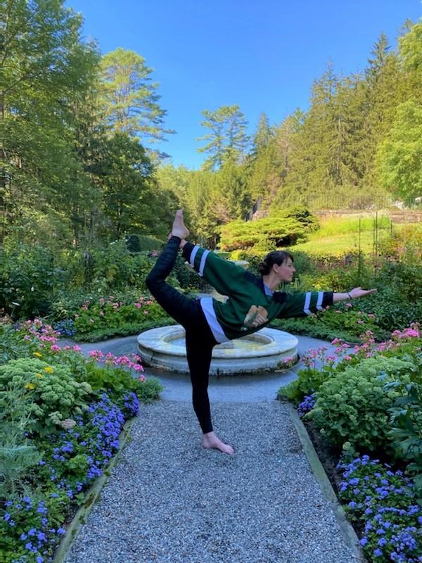 A ranger performs dancer's pose in the garden.