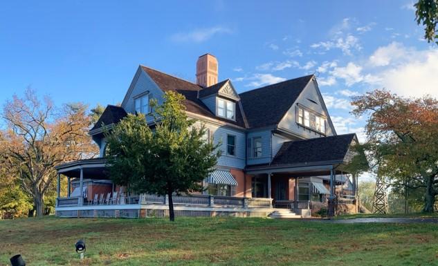 Theodore Roosevelt's Home with the sun shining on it, trees in front