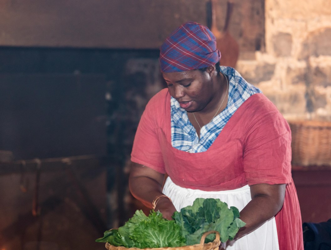 Cast iron pots and pans in front of a stone fireplace.