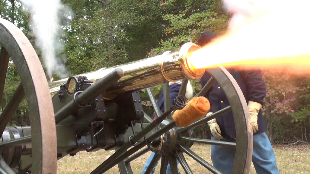Flames shoot out of a cannon barrel.